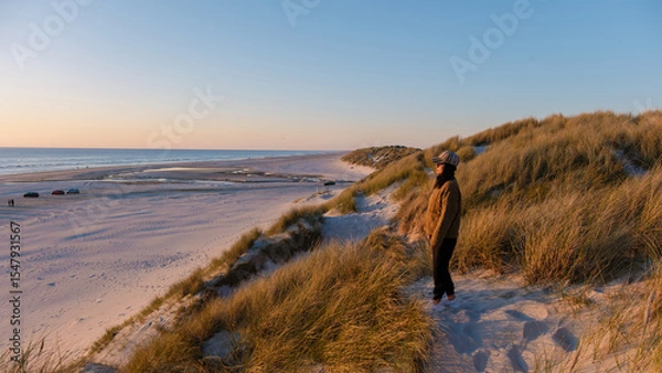 Fototapeta Stunning sunset at a serene beach in Denmark revealing golden sands and gentle waves
