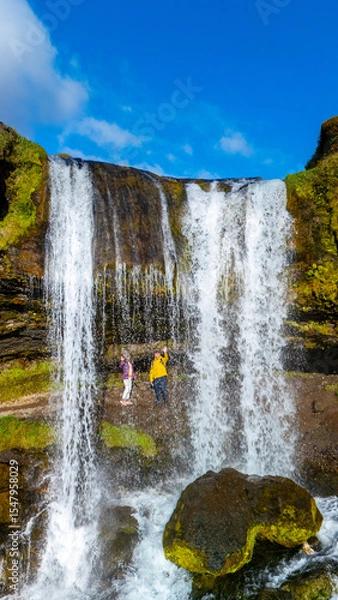 Fototapeta Majestic Seljalandsfoss waterfall in Iceland reveals natural beauty amidst adventurous exploration