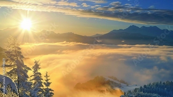 Fototapeta A golden sunrise over the snow-covered Alps, with clouds and sun rays visible from the top of the mountain peak. 