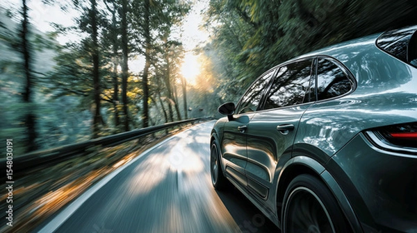 Fototapeta A modern gray SUV speeds along a winding, sun-drenched forest road, captured with dynamic motion blur, highlighting adventure, nature, and the thrill of the journey.

