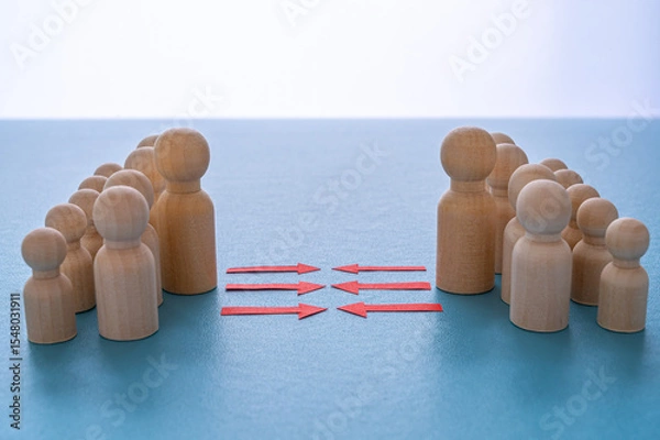 Fototapeta Concept of conflict I war between people or groups. Wooden figures gathered in two groups facing each other.