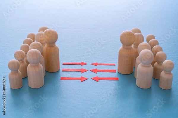 Fototapeta Concept of conflict I war between people or groups. Wooden figures gathered in two groups facing each other.