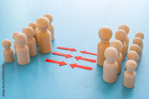 Fototapeta Concept of conflict I war between people or groups. Wooden figures gathered in two groups facing each other.