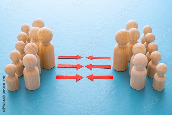 Fototapeta Concept of conflict I war between people or groups. Wooden figures gathered in two groups facing each other.