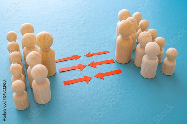 Fototapeta Concept of conflict I war between people or groups. Wooden figures gathered in two groups facing each other.
