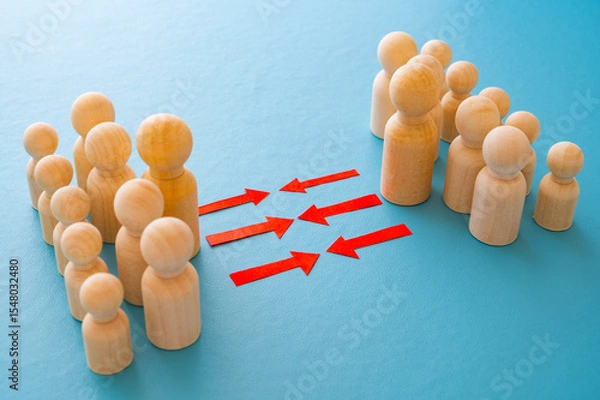 Fototapeta Concept of conflict I war between people or groups. Wooden figures gathered in two groups facing each other.