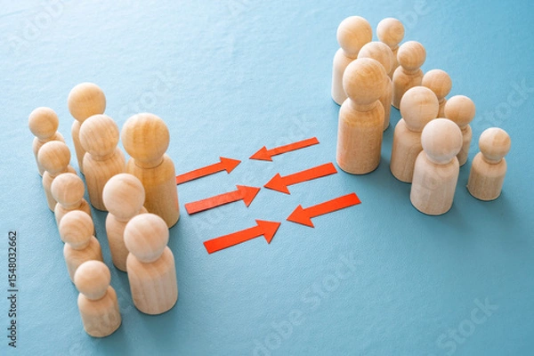 Fototapeta Concept of conflict I war between people or groups. Wooden figures gathered in two groups facing each other.
