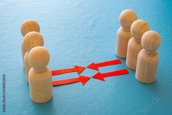 Fototapeta Concept of conflict I war between people or groups. Wooden figures gathered in two groups facing each other.