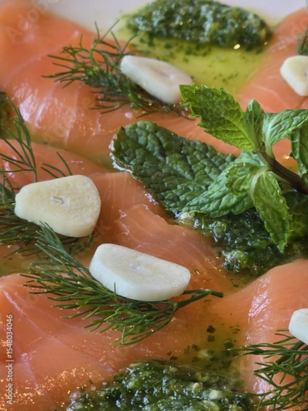 Obraz Fresh salmon fillet garnished with herbs, garlic, and mint, drizzled with olive oil. vibrant and appetizing dish perfect for seafood lovers