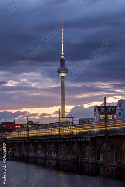 Obraz The famous Television Tower and the river Spree with a motion blurred commuter train in Berlin at twilight