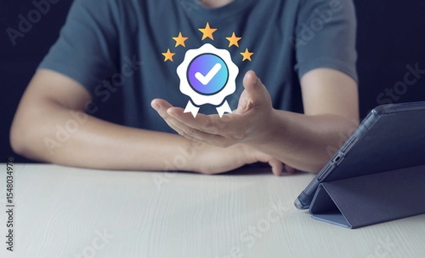 Fototapeta A quality assurance icon floats above a hand, symbolizing certified business, trusted services, and verified shops. This concept is ideal for visuals related to e-commerce.