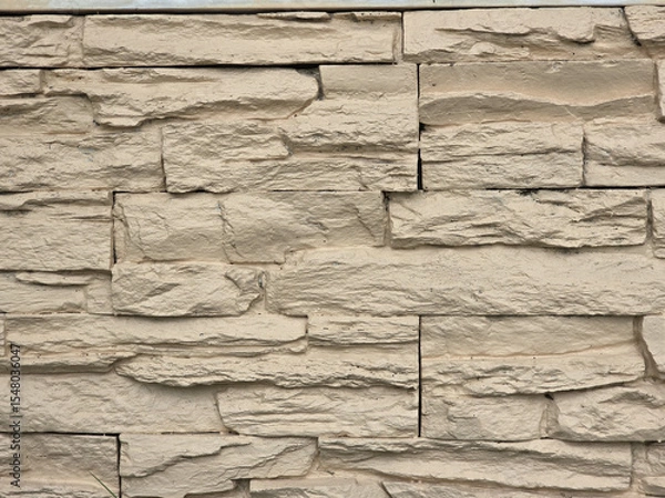 Obraz Textured beige stone wall with natural, rugged appearance, ideal for architectural designs and landscaping. uneven surfaces create visually appealing backdrop