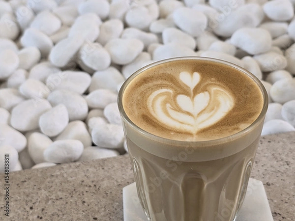 Obraz Coffee with latte art featuring heart shapes, placed on stone background, creating serene and inviting atmosphere