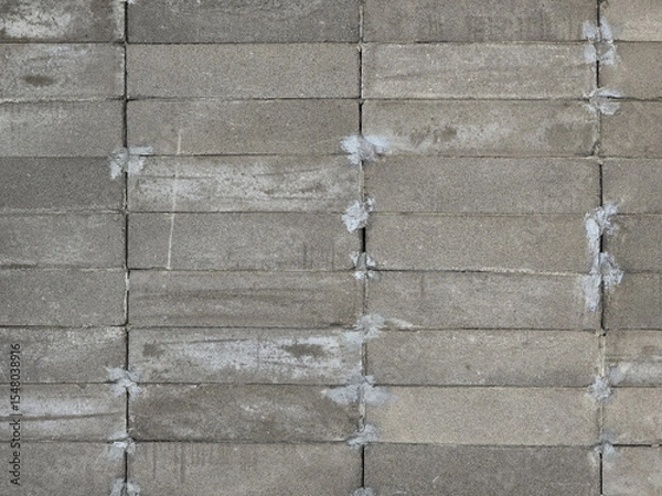Obraz Textured gray concrete blocks arranged in uniform pattern, showcasing rough surface and mortar joints. This captures industrial aesthetic of masonry work