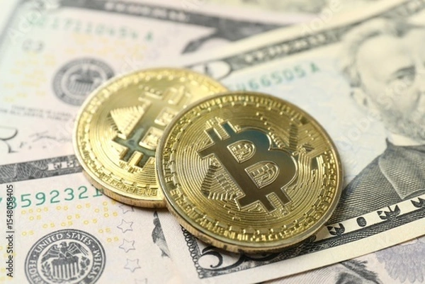 Fototapeta Close up of metal shiny bitcoin crypto currency coins on US dollar bills. Electronic decentralized money concept. 