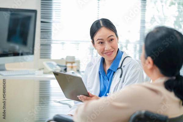 Fototapeta experienced female medical professional explains test results to a female patient during a clinic consultation. reviewing reports and discussing diagnosis and treatment options.compassionate care