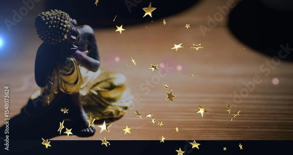 Fototapeta Resting seated Buddha figurine wearing golden robe on wood table at home, star overlays, copy space