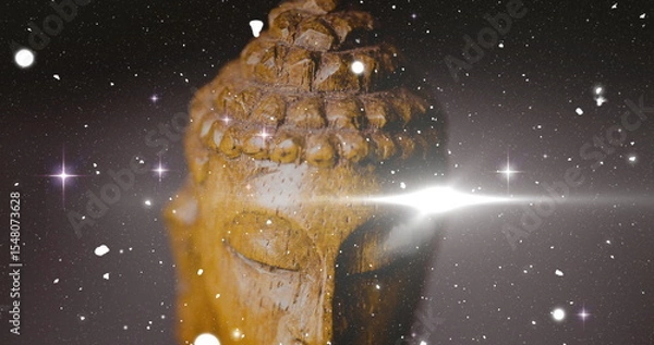 Fototapeta Glowing wooden Buddha head sculpture showing curls against dark backdrop with lens flare, sparkles
