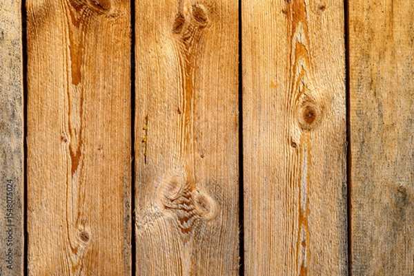 Fototapeta Wooden planks display a rustic charm with visible grain patterns and knots. The natural hues of brown and tan provide a warm and inviting appearance,for copy space.