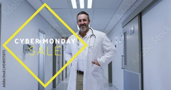 Obraz Standing bearded doctor wearing lab coat in hospital corridor, featuring Cyber Monday Sale graphic