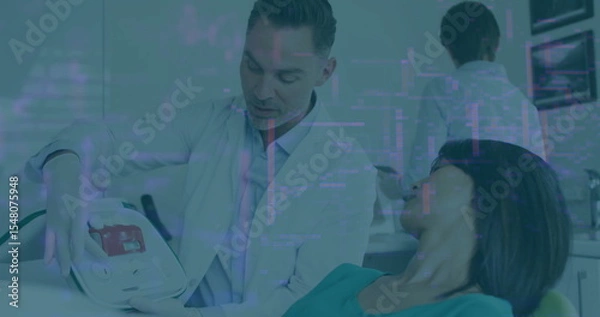Obraz Explaining dentist in white lab coat showing panel by dental chair, with protective bib