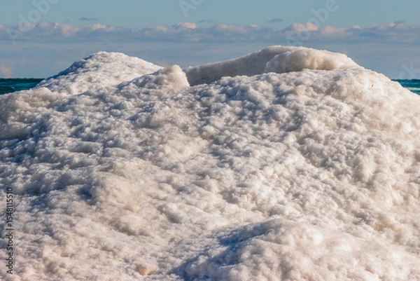 Fototapeta The top of an ice volcano on the shore of Lake Michigan at Harrington Beach State Park, Belgium, Wisconsin, quiet with the calm water in early January