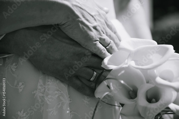 Obraz Close up of hands of bride and groom with rings and flowers