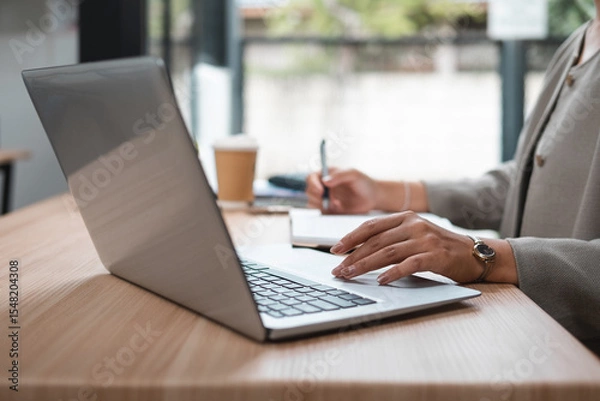 Fototapeta Young woman's hand pressing a button on a laptop keyboard