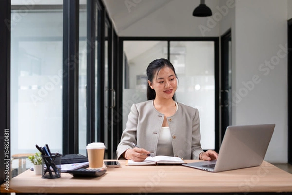 Obraz Businesswoman working with laptop in office, smiling face