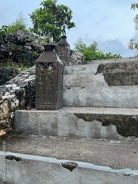 Obraz Staircase and Lanterns: An image captures an old staircase leading upwards, adorned with vintage lanterns. This captures the essence of history, nature, and enduring design. 