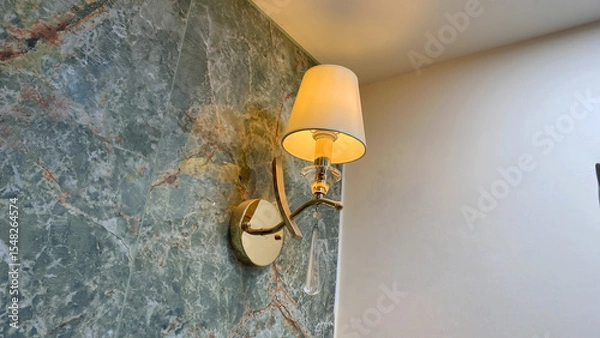 Fototapeta Elegant Wall Sconce Lamp with White Lampshade and Crystal Drop on Luxury Green Marble Wall in Modern Interior