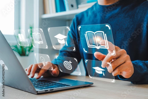 Obraz Person engaging with virtual educational icons on a laptop represents modern e-learning. The interface displays books, graduation caps, and targets, symbolizing online education innovations.