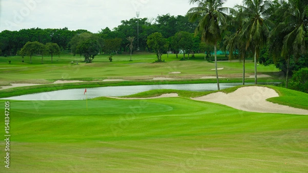 Fototapeta Golf Course with Sand Bunkers and Palm Trees in Tropical Setting.