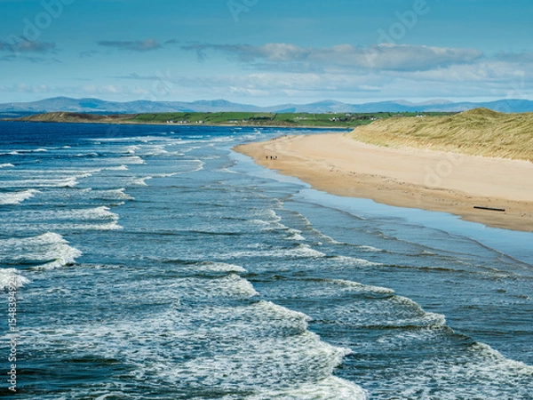 Fototapeta Powerful ocean waves and rich blue water of the ocean, Bundoran town, Ireland. Popular tourist area with stunning view and surfing area. Warm sunny day. Travel and tourism. Irish landscape.
