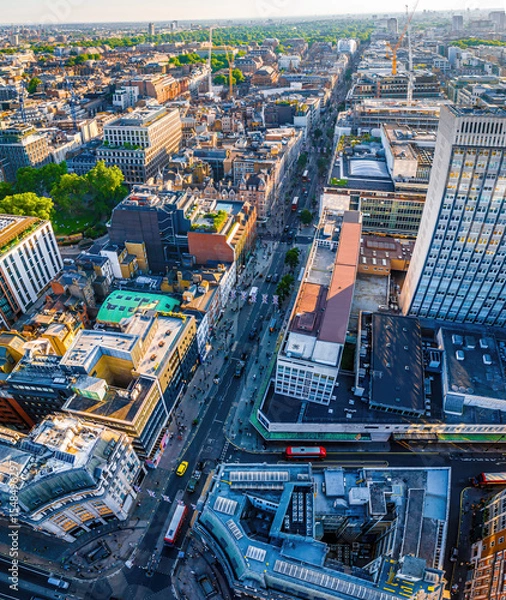 Fototapeta Aerial view of Oxford Street in London with bustling traffic, classic buildings, and red double-decker buses on a sunny, clear day.