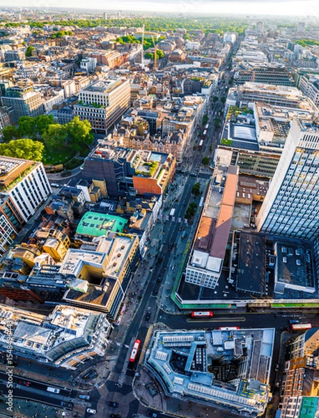 Fototapeta Aerial view of Oxford Street in London with bustling traffic, classic buildings, and red double-decker buses on a sunny, clear day.