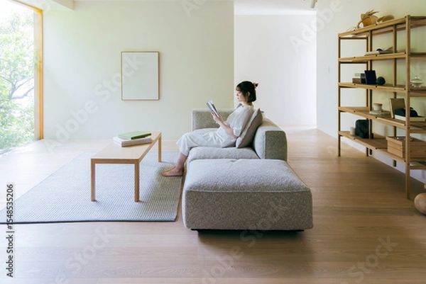 Fototapeta リビングで本を読む女性