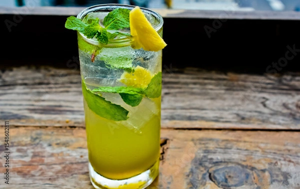 Fototapeta view of a glass of lime ice with mint leaves and lemon topping