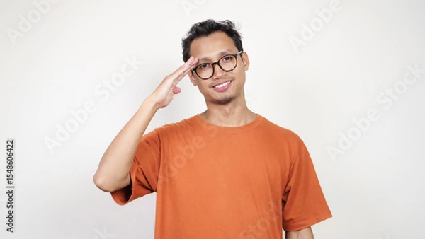 Obraz A man in an orange shirt is saluting