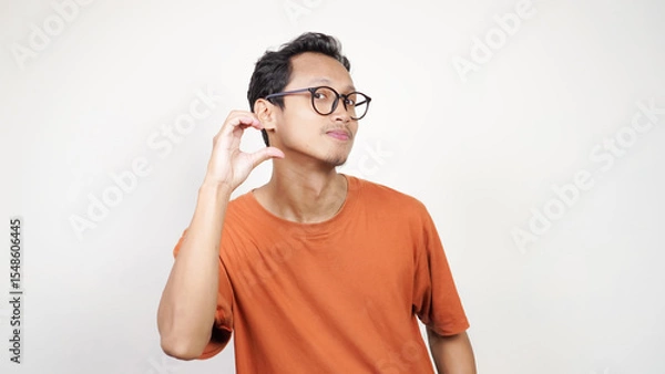 Obraz A man in an orange shirt is smiling and pointing to the camera