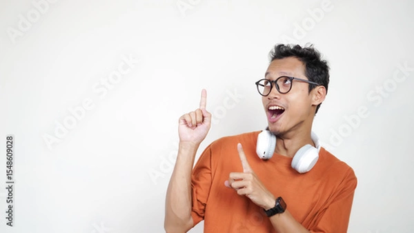 Obraz A man in an orange shirt points to the sky with his finger