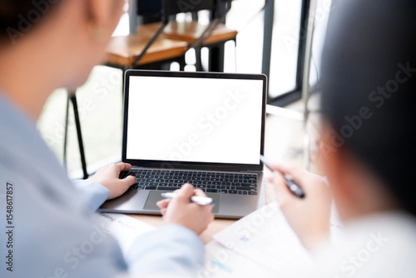 Fototapeta Mockup image of a two woman using laptop with blank screen on wooden table