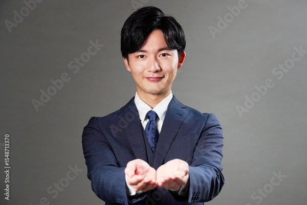 Obraz 両手を差し出すビジネスマン　黒背景