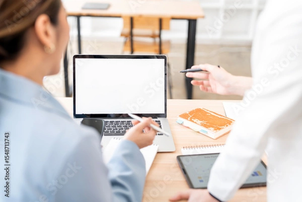 Obraz Mockup image of a two woman using laptop with blank screen on wooden table