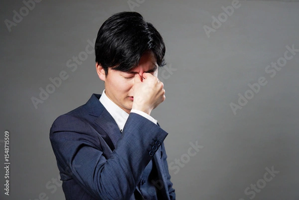 Obraz ビジネスマン　眼精疲労　黒背景