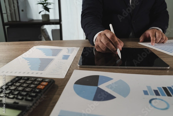 Obraz Report document person formal attire working with digital and printed data wooden desk, using tablet and stylus for analysis or presentation