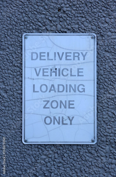 Fototapeta Delivery Vehicle Loading Zone Only sign mounted on the wall of a building
