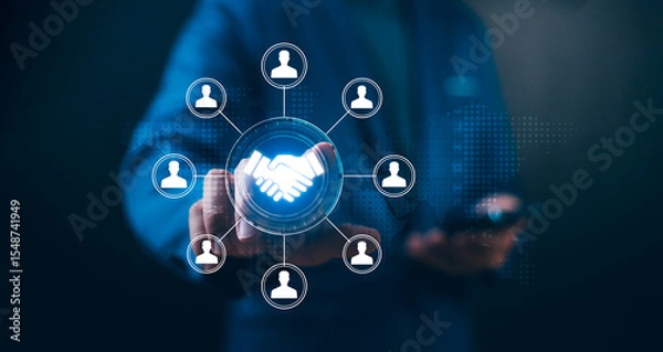 Fototapeta Businessman touches a handshake icon connected to a team network. Concept of Human Resource Management (HRM), team building, Customer Relationship Management (CRM), and business partnership.
