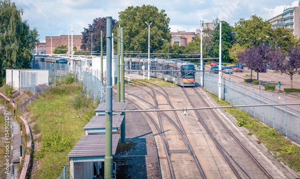 Fototapeta Power supply communications for tram Tramway tracks and vehicles at a transit yard under a clear sky during daytime