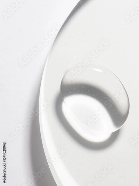 Fototapeta A transparent liquid drop on white background, abstract cosmetic product swatch for market palce